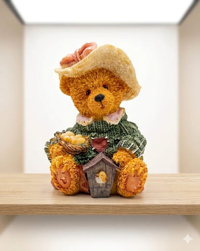 Detailní figurka medvědice se slaměnýmkloboukem a ptačí budkou.