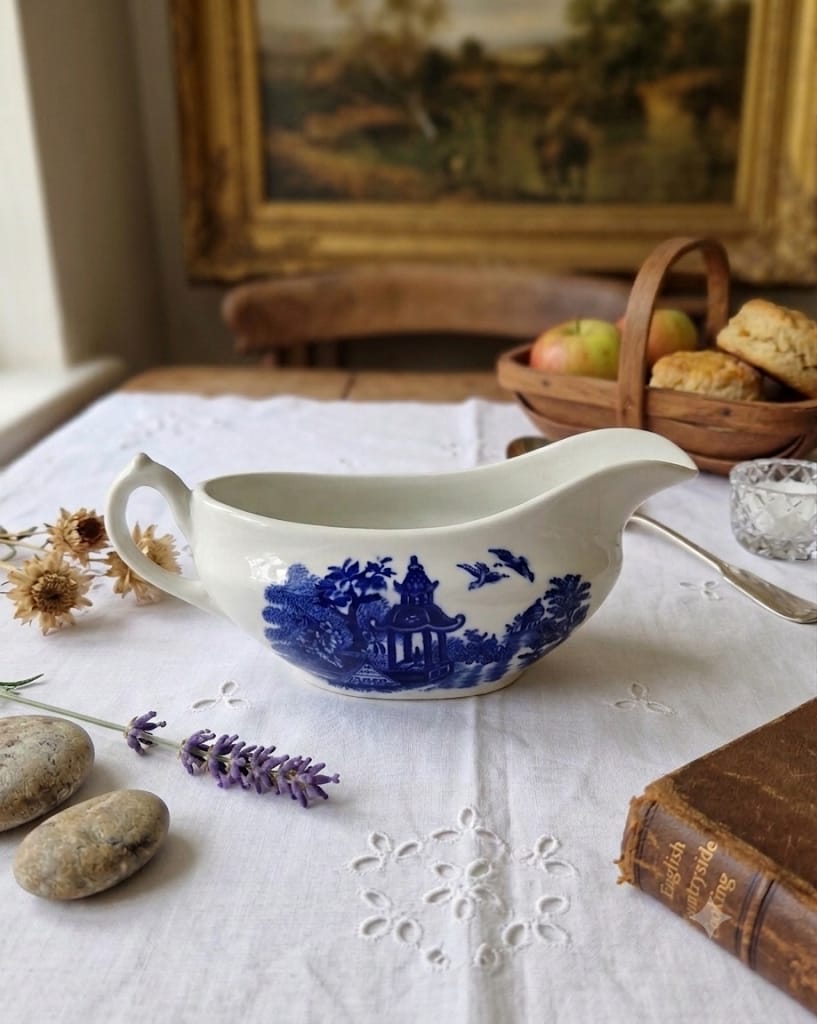 Starožitný omáčník Swinnertons Olde Alton Ware na dřevěném stole z boku.